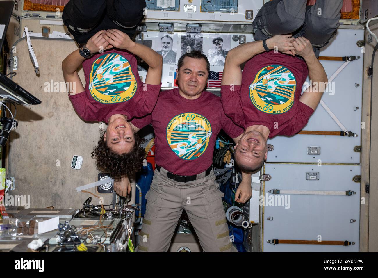 Iss062e000449 (7. Februar 2020) ---- die dreiköpfige Expedition 62-Crew mit ihrem Mission Patch auf T-Shirts wird bis April dieses Jahres an Bord der Internationalen Raumstation leben. In der Mitte befindet sich Roscosmos-Kommandant Oleg Skripochka, flankiert von den NASA-Flugingenieuren Jessica Meir und Andrew Morgan. Stockfoto