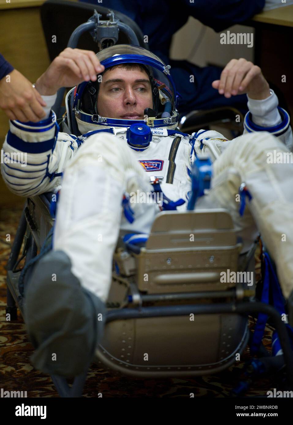 Der Kommandeur der Sojus-Expedition 28, Sergej Wolkow, wird auf dem Kosmodrom Baikonur mit den Crewmitgliedern Mike Fossum und Satoshi Furukawa einer Druckprüfung seines russischen Sokol-Anzugs unterzogen. Stockfoto