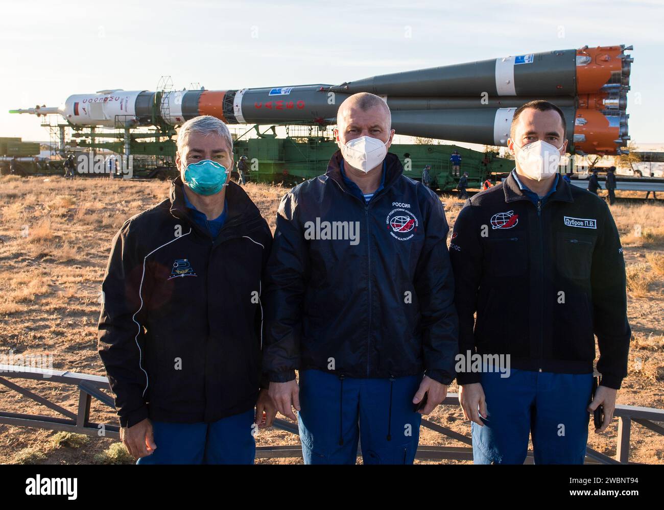 Expedition 64 Besatzungsmitglieder NASA-Astronaut Mark Vande Hei, links, und russische Kosmonauten Oleg Nowitskiy, Zentrum, und Petr Dubrov, rechts, von Roscosmos, posieren Sie für ein Foto, während die Sojus-Rakete mit dem Zug zum Startplatz auf der Site 31 am Sonntag, 11. Oktober 2020, im Baikonur-Kosmodrom in Kasachstan ausgerollt wird. Expedition 64 die russischen Kosmonauten Sergej Ryzhikow und Sergej Kud-Swerchkow aus Roscosmos sowie die NASA-Astronautin Kate Rubins sollen am 14. Oktober an Bord ihres Raumschiffs Sojus MS-17 starten, um eine sechsmonatige Mission an Bord der Internationalen Raumstation zu starten. Stockfoto