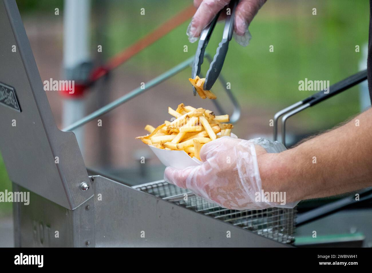 Eine Person serviert frische Pommes frites Stockfoto