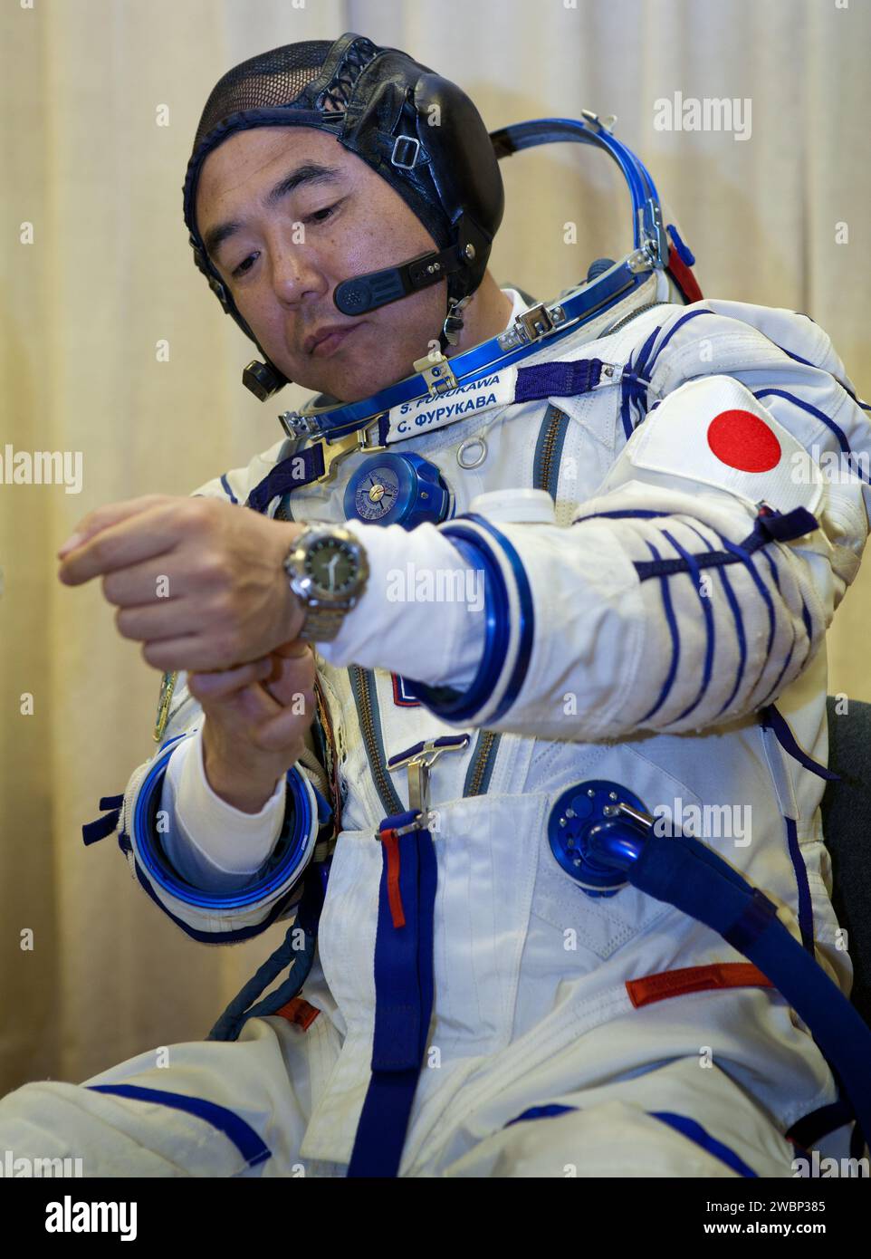 JAXA Astronaut Satoshi Furukawa bereitet seinen russischen Sokol-Anzug für den Sojus-Start vom Baikonur Cosmodrome am 8. Juni 2011 mit den Besatzungsmitgliedern Sergei Volkov und Mike Fossum vor. Stockfoto