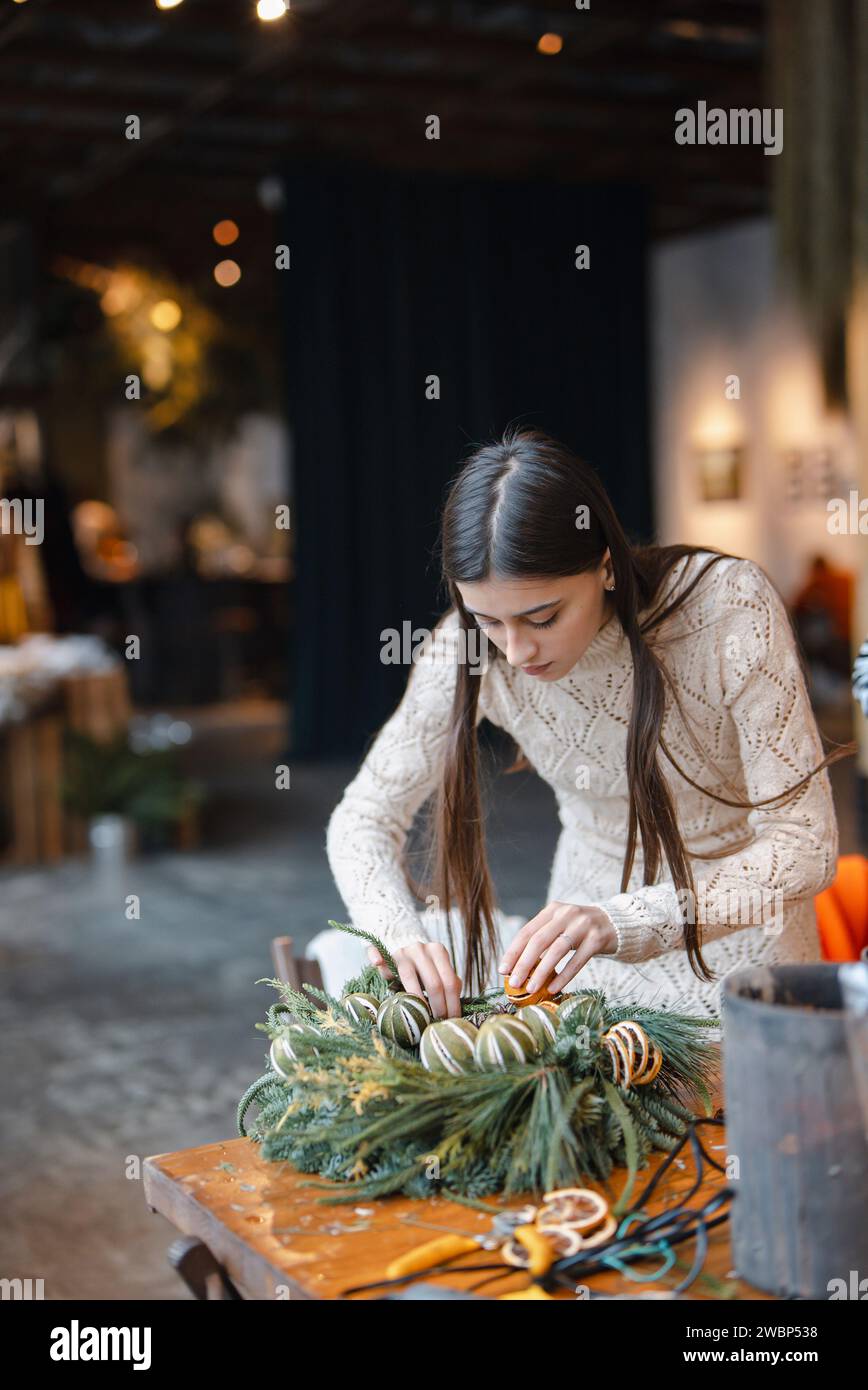 Der Weihnachtskranz, der zur Ausstellung bereit ist, wird am Blumenladen fertig gestellt. Stockfoto