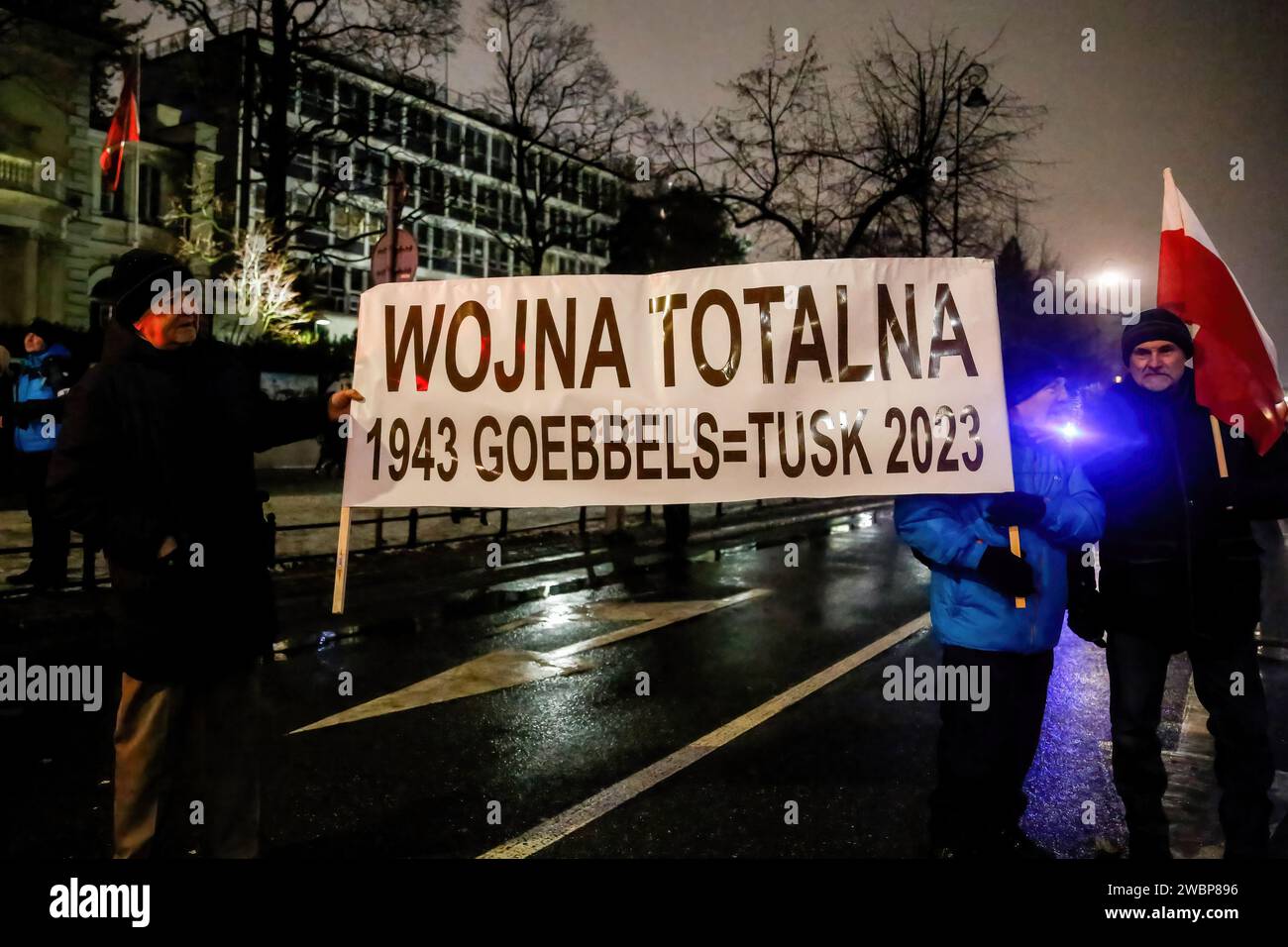 Die Demonstranten halten während der Demonstration ein Banner mit der Aufschrift „Total war 1943 Goebbels gleich Tusk 2023“. Protest gegen Veränderungen in den öffentlichen Medien in Polen und gegen den Schutz der Demokratie - sagen die Politiker der PI. Die Partei Recht und Gerechtigkeit herrschte acht Jahre in Polen, bis sie die letzte Wahl im Oktober 2023 verlor. Die Partei wird nun zu einer rechten Oppositionstruppe gegen eine stärker zentristische und liberalere Regierungskoalition, wo die wichtigste politische Kraft die Bürgerkoalition unter der Führung von Donald Tusk ist, dem ehemaligen Präsidenten des EU-Rates und heutigen Premierminister Polens. Stockfoto