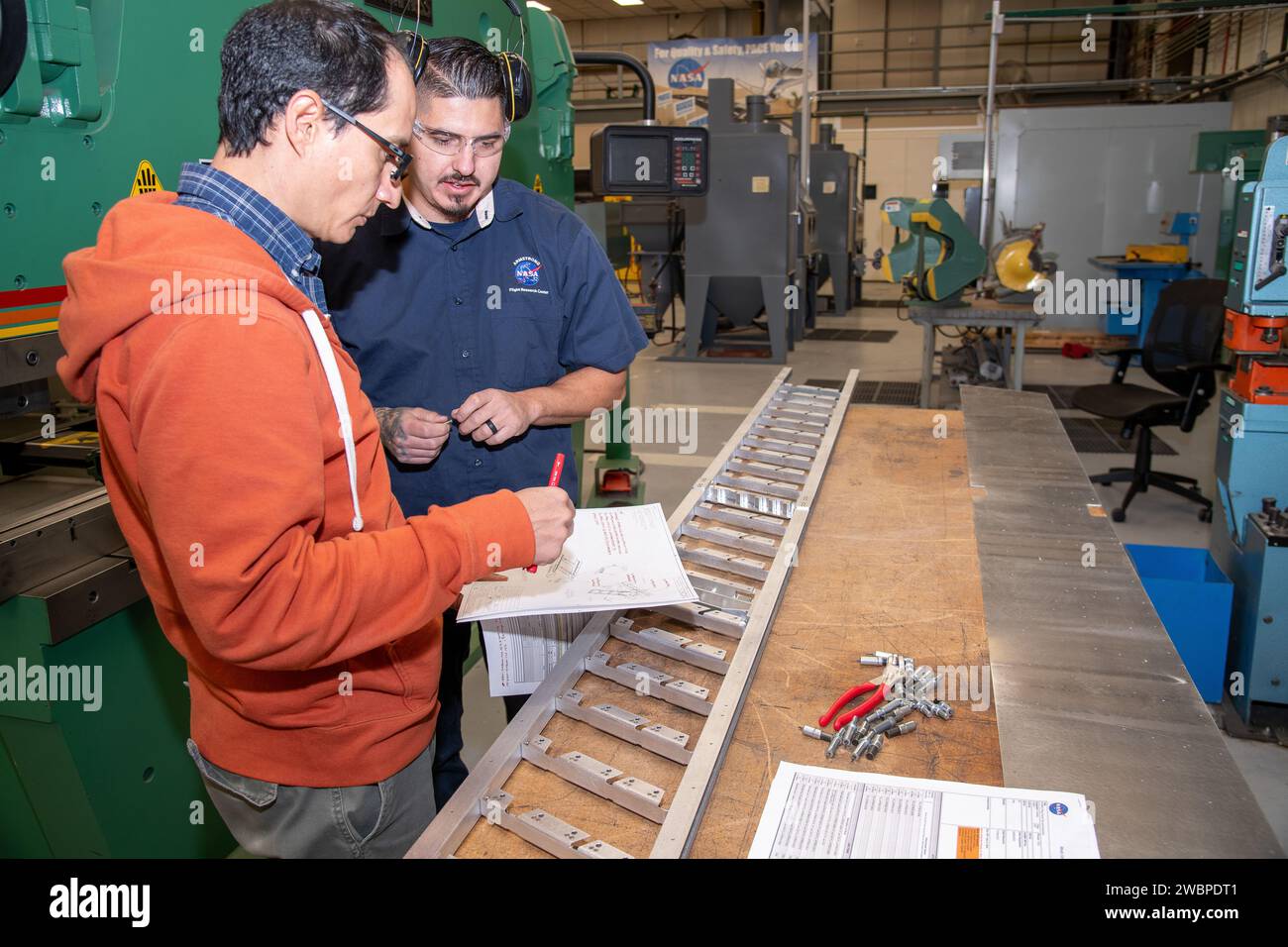 Matthew Sanchez berät sich mit Andrew Holguin über die Strebe für ein 10-Fuß-Modell des transonischen Truss-Brake Wing im Armstrong Flight Research Center der NASA in Edwards, Kalifornien. Das Flugzeugkonzept beinhaltet einen Flügel, der mit diagonalen Streben an einem Flugzeug befestigt ist, die ebenfalls Auftrieb verleihen und zu einer deutlich verbesserten Aerodynamik führen könnten. Stockfoto