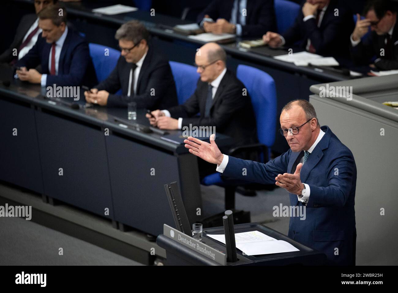 Friedrich Merz, Olaf Scholz - Bundestag DEU, Deutschland, Deutschland, Berlin, 13.12.2023 Rede von Friedrich Merz , Vorsitzender der CDU und Oppositionsführer mit im Hintergrund die Regierungsbank mit Christian Lindner , Bundesfinanzminister FDP, Robert Habeck , Bundesminister für Wirtschaft und Klimaschutz und Vizekanzler, Buendnis 90 die Grünen und Olaf Scholz , Bundeskanzler SPD waehrend der Plenarsitzung zur Debatte zum bevorstehenden Gipfel des Europaeischen Rates und Stellungnahme an den Bundestag zum Haushalt im Plenarsaal Deutscher Bundestag in Berlin Deutschland. Die Koalition Hut in le Stockfoto