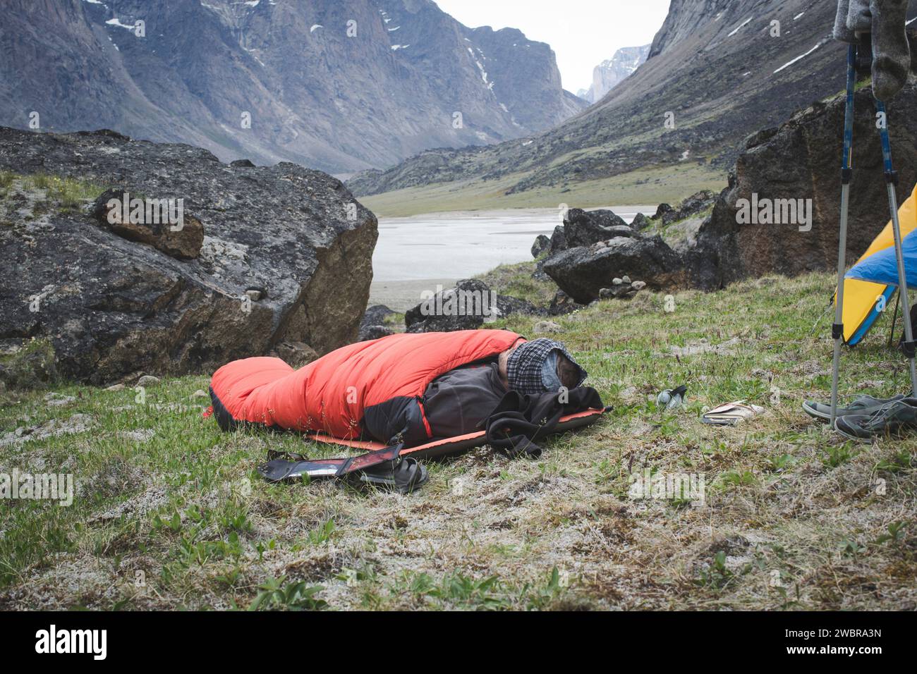 Wanderer ruht im Schlafsack in den Bergen, Baffin Island, Nunavut, Kanada Stockfoto