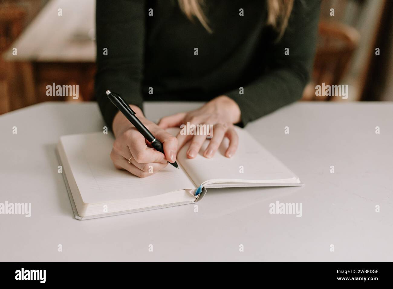 Frau, die ein neues Notizbuch für Neujahr anfängt Stockfoto