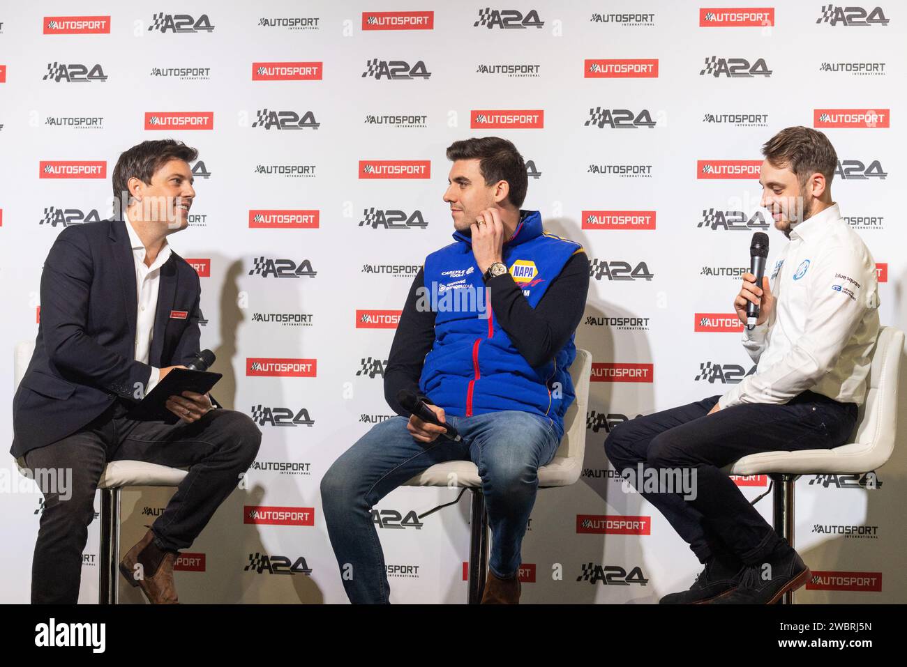 Birmingham, Großbritannien. Januar 2024. Moderator Bryn Lucas (links) spricht mit den BTCC-Fahrern Dan Cammish (Mitte) und Jake Hill (rechts) auf der Hauptbühne des Autosport International 2024. Credit Milo Chandler/Alamy Live News Stockfoto