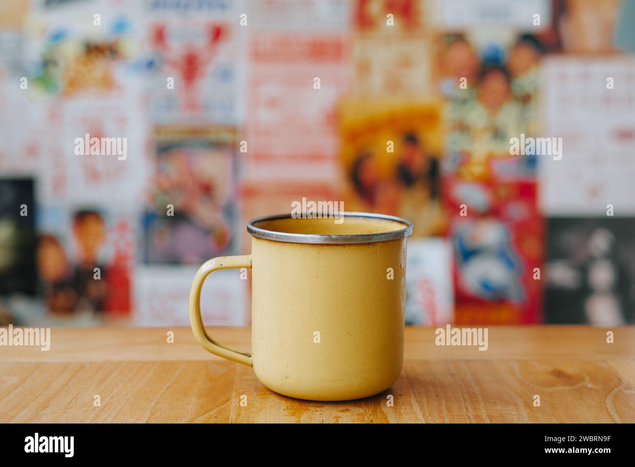 Schokoladengetränk mit Pulver auf gelbem Emaillebecher mit Bokeh-Hintergrund Stockfoto