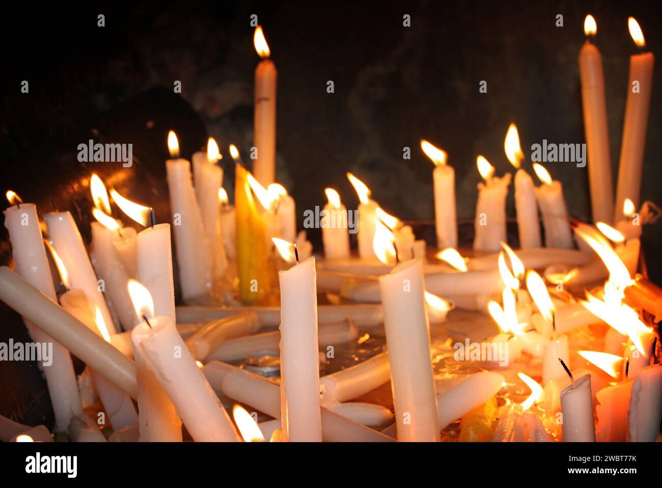 Brennende Kerzen schmelzen in Stille in einer Kirche des Libanon. Stockfoto