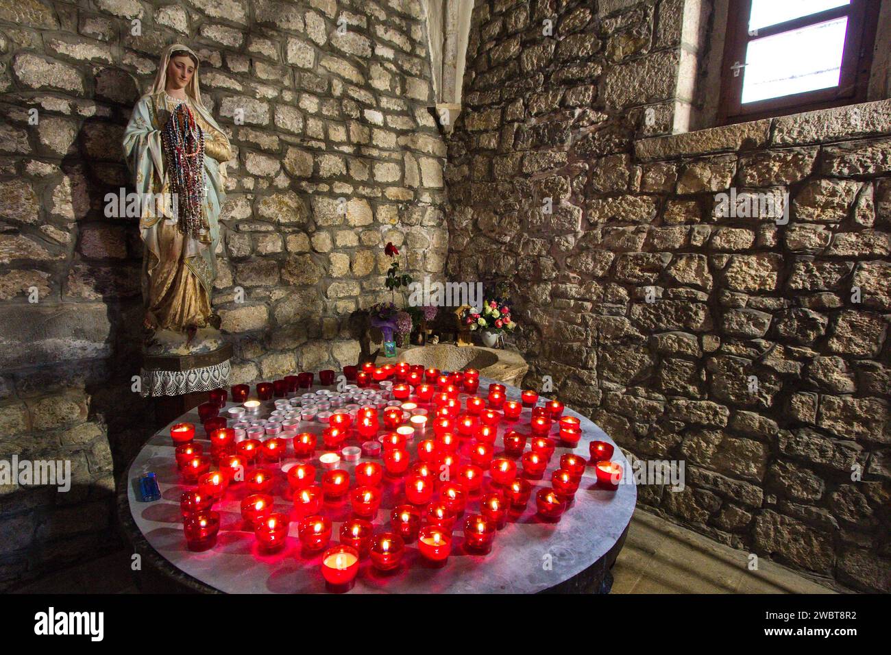 Die Kirche des Heiligen Franziskus und ihr Kloster in Krk Stadt, Insel Krk Kroatien - das Innere der Kapelle. Kerzen mit der Marienstatue. Stockfoto