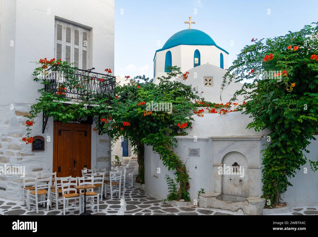 Typisch weiß getünchte griechische Kirche mit blauer Kuppel an der Straßenecke, Paros Island, Griechenland Stockfoto