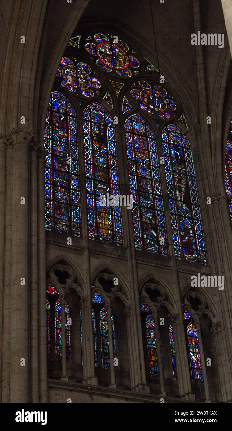 Farbenprächtige Buntglasfenster aus dem XIII. Jahrhundert im Kirchenschiff von St. Paul und St. Peter Kathedrale in Troyes, Frankreich, durch einen Steinbogen gesehen. Stockfoto