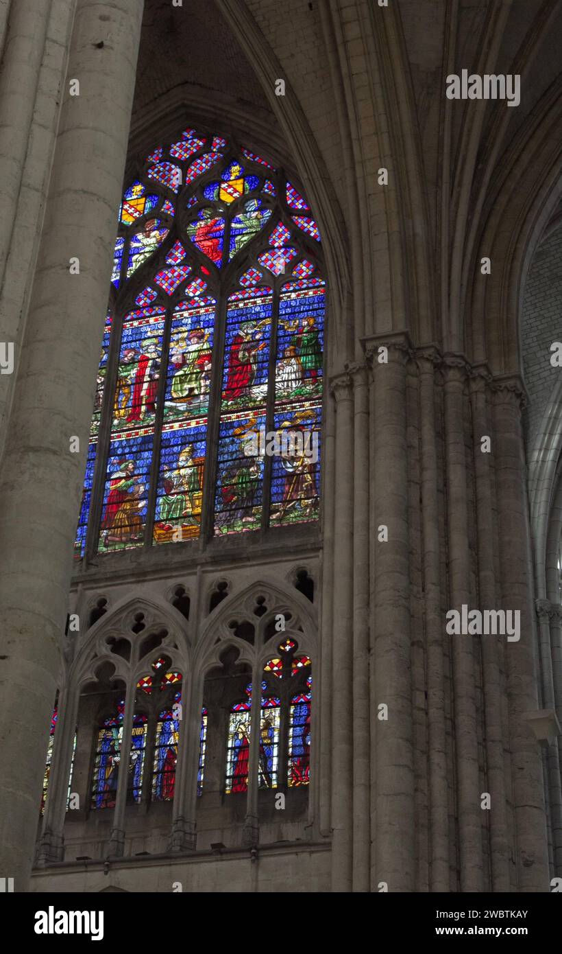 Farbenprächtige Buntglasfenster aus dem XIII. Jahrhundert im Kirchenschiff von St. Paul und St. Peter Kathedrale in Troyes, Frankreich, durch einen Steinbogen gesehen. Stockfoto