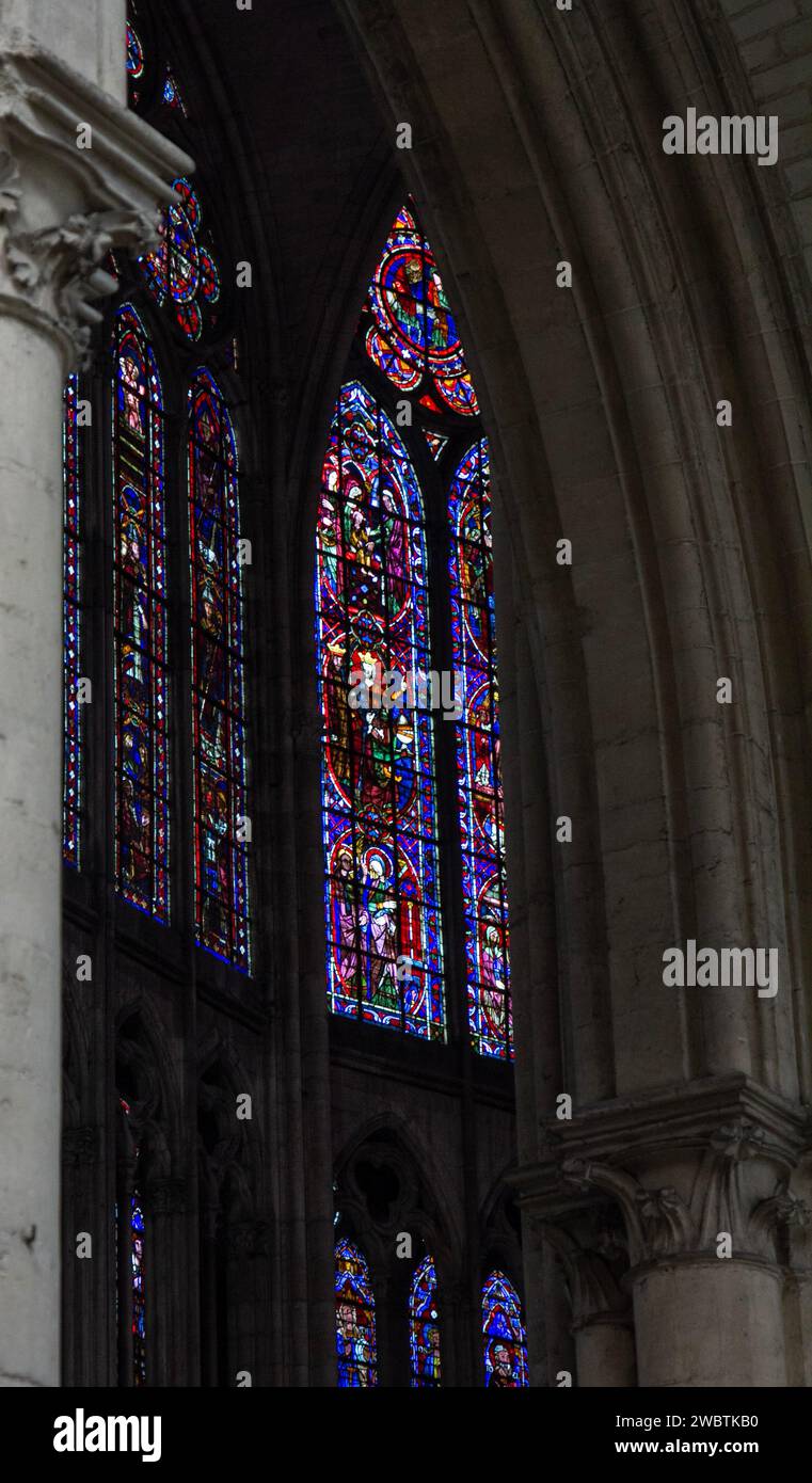 Farbenprächtige Buntglasfenster aus dem XIII. Jahrhundert im Kirchenschiff von St. Paul und St. Peter Kathedrale in Troyes, Frankreich, durch einen Steinbogen gesehen. Stockfoto