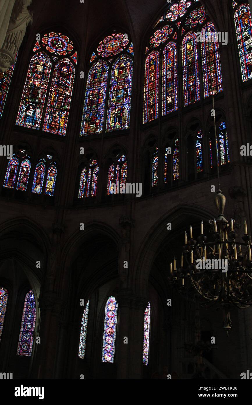Die Buntglasfenster aus dem XIII. Jahrhundert der Kathedrale St. Paul und St. Peter in Troyes, Frankreich, leuchten hell im dunklen Inneren des gotischen Gebäudes. Stockfoto