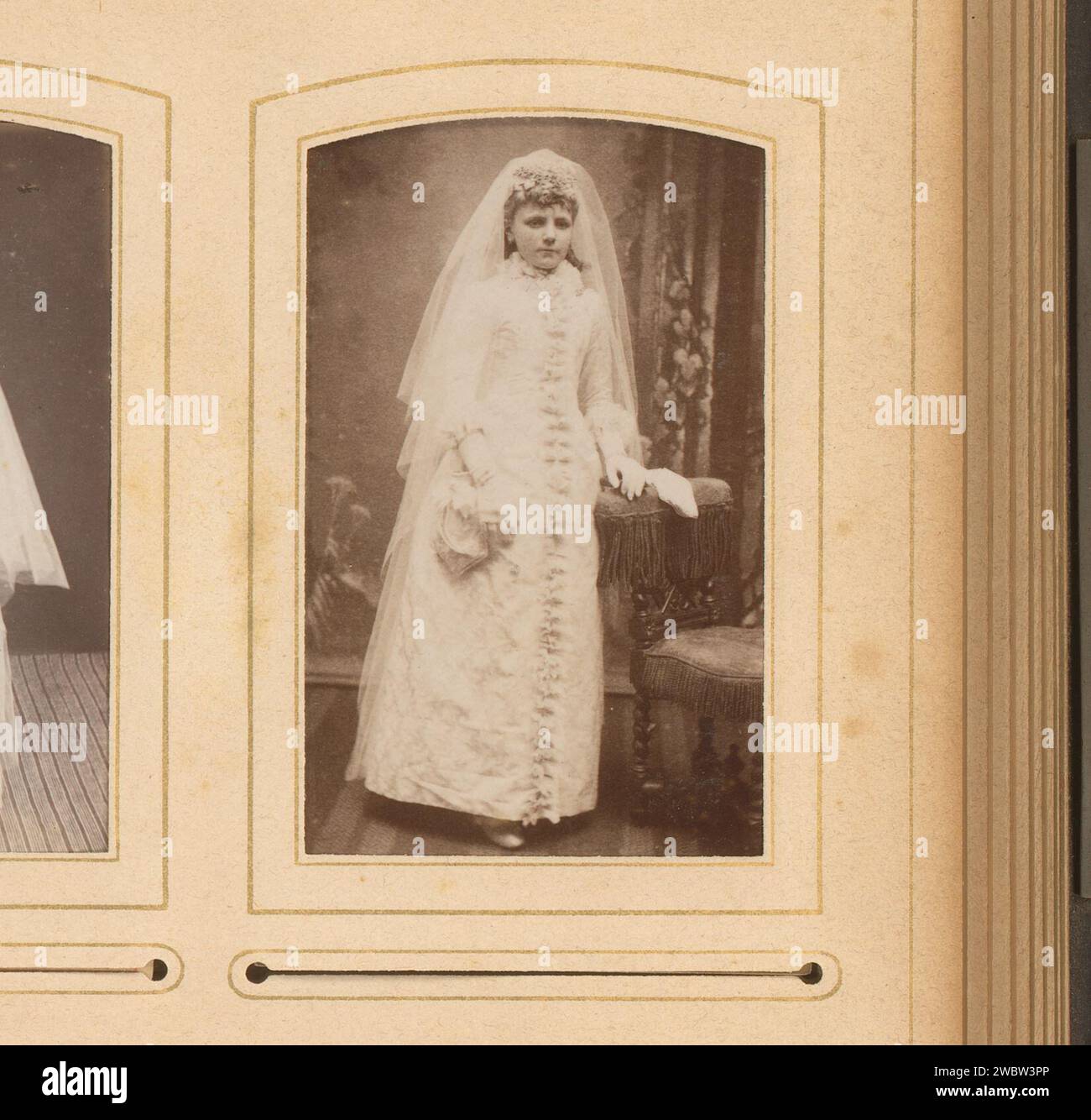 Porträt eines Mädchens im Kommunionkleid, stehend an einem Stuhl, Hermanus Jodocus Weesing, 1868 - 1900 Foto. Visitenkarte dieses Foto ist Teil eines Albums. Unterstützung für Fotos in Amsterdam. Pappalbumendruck historische Personen - BB - Frau. Mädchen (Kind zwischen Kleinkind und Jugend). Kommunionkleid. Stuhl Stockfoto