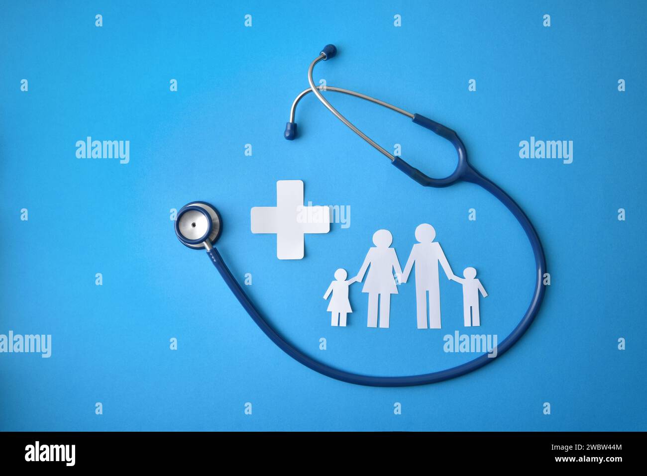 Familiengesundheitskonzept mit Stethoskop- und Weißpapierfamilie und Querausschnitten auf blauem Hintergrund. Draufsicht Stockfoto