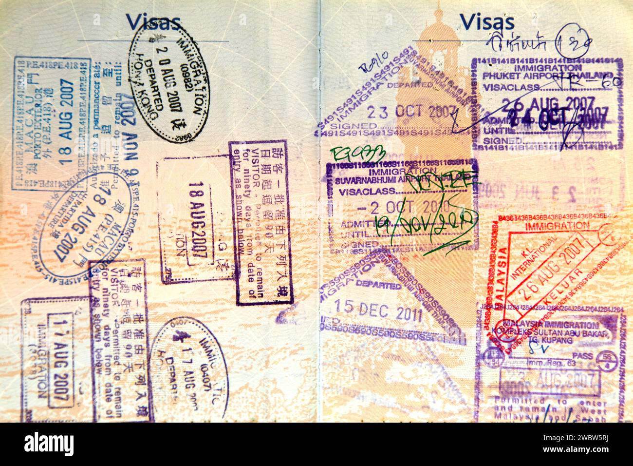 Nahaufnahme auf den Doppelseiten eines französischen biometrischen Passes, gefüllt mit Briefmarken aus Thailand, Malaysia, Hongkong und Macau. Stockfoto