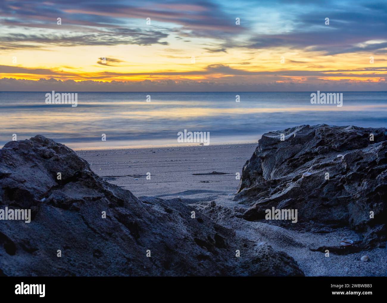 Ruhiger Sonnenaufgang am Strand, perfekt für Reisebroschüren, Meditationshintergründe und Web-Design mit Naturmotiven. Stockfoto