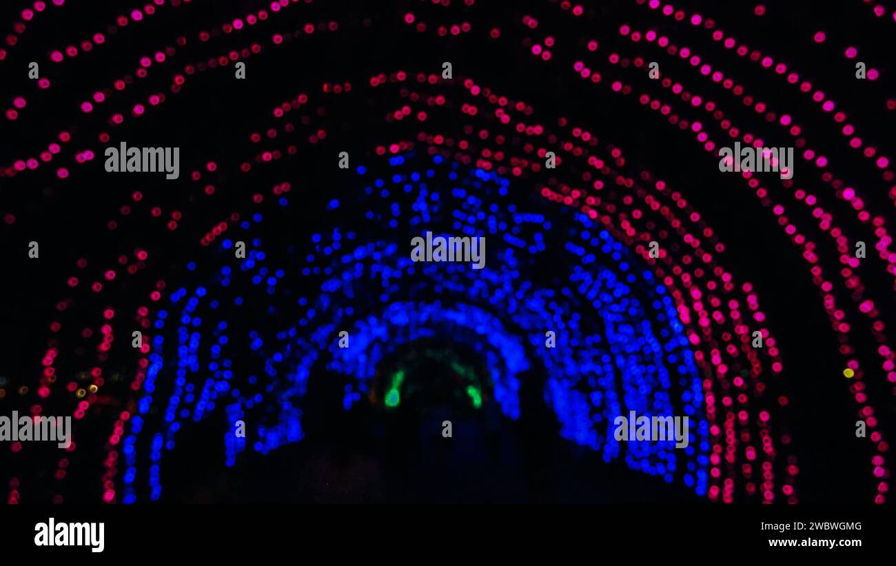 Abstraktion von verschwommenen, farbigen Lichtern festlicher Beleuchtung. Abstrakte mehrfarbige Lichter. Buntes Bokeh, helle, verschwommene Weihnachtslichter. Partyzeit, Stockfoto