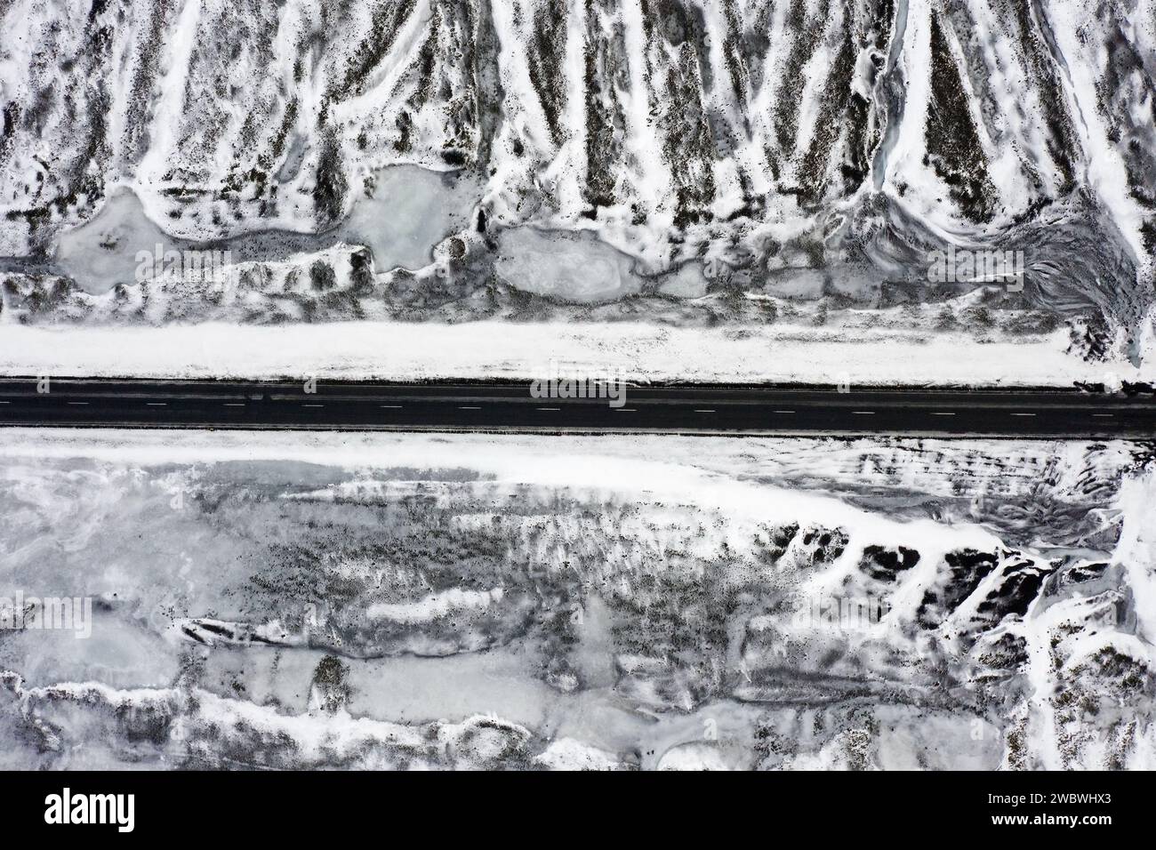 Aus der Vogelperspektive über die leere Route 1 / Ring Road, zweispurige Nationalstraße in einer verschneiten Winterlandschaft, Suðurland / Südregion, Island Stockfoto