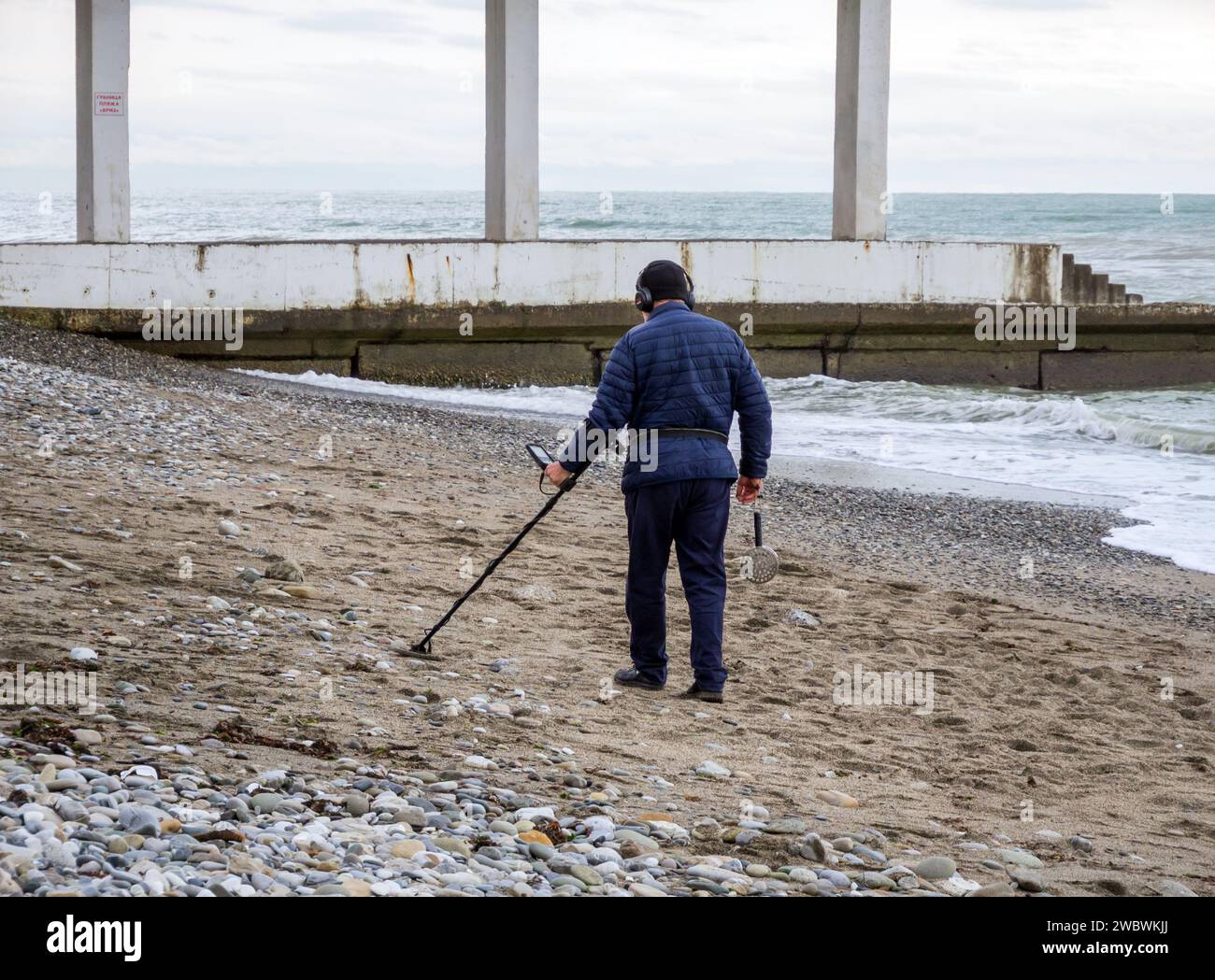 Sotschi, Russland - 2023. Februar: Suche mit einem Metalldetektor an einem Winterstrand nach einem Sturm Stockfoto