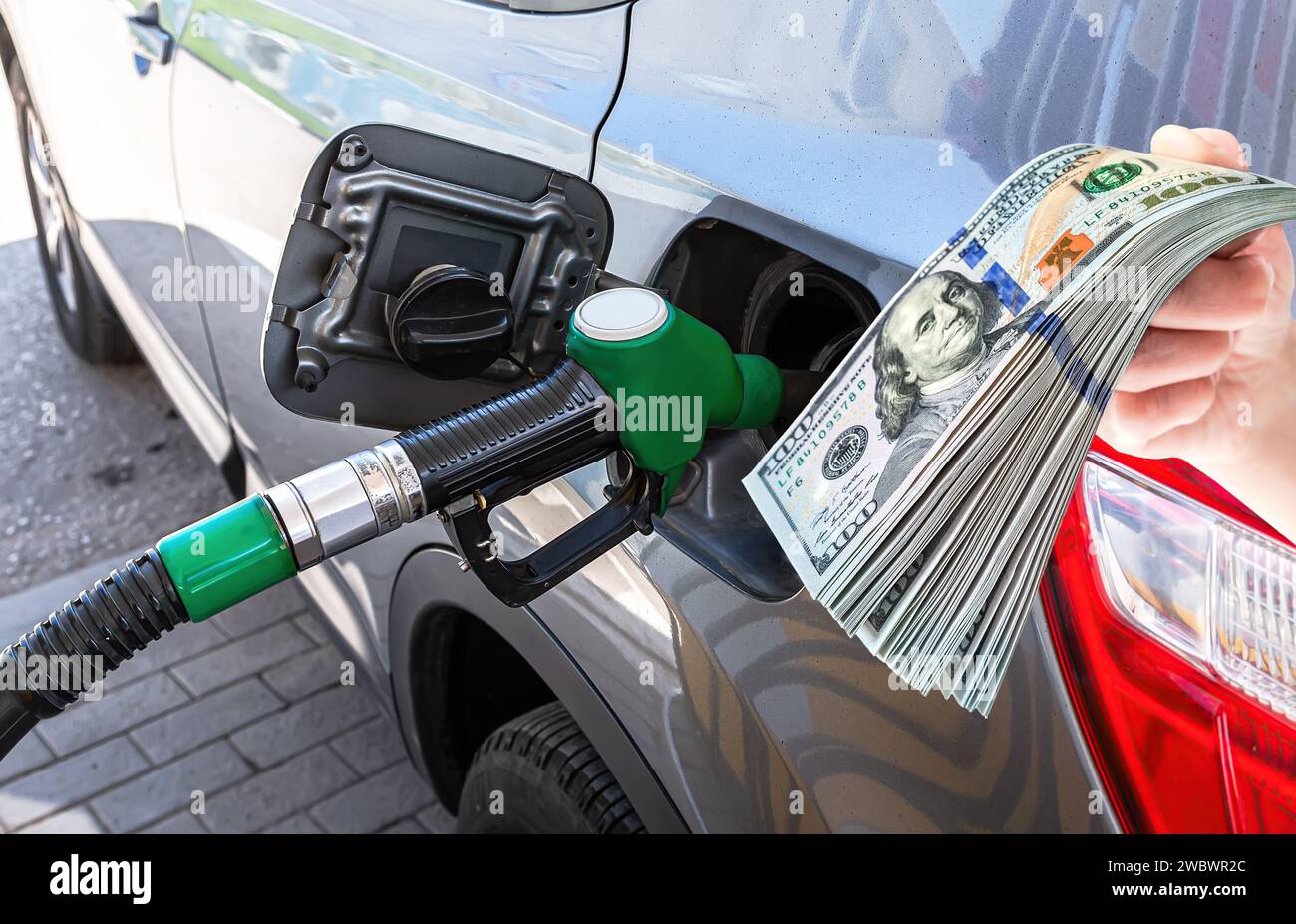 Kraftstoffdüse, um Kraftstoff an der Tankstelle in den PKW und Dollar abzulassen Stockfoto