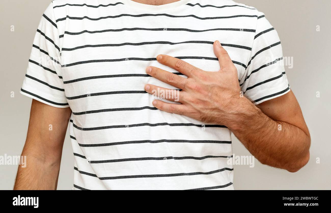 Heartache-Konzept. Ein Mann, der seine Brust mit der Hand berührt. Hand am Herzen. Stockfoto