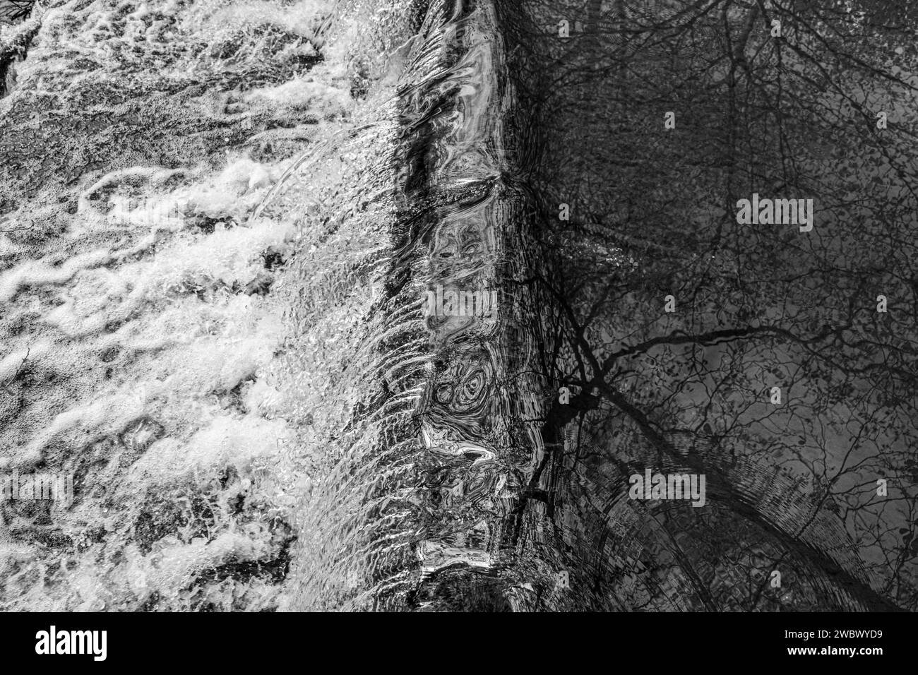 Wasserkaskadierung über Wehr mit weißem Schaumwasser Stockfoto
