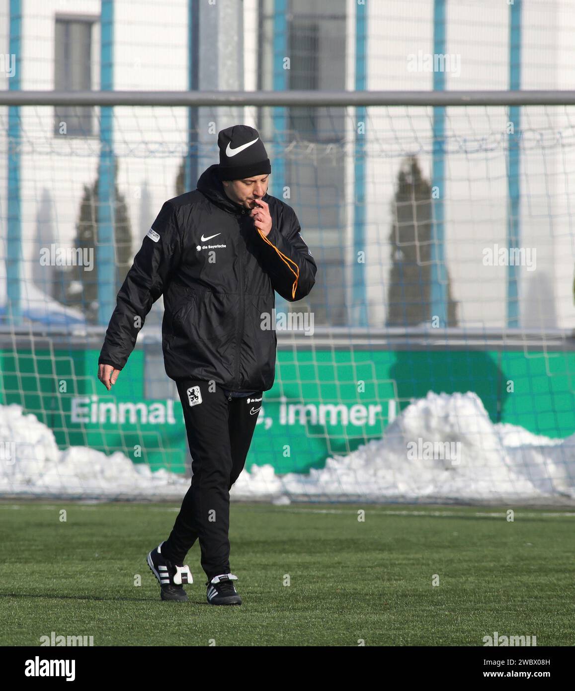 München, Deutschland 12. Januar 2024: Fussball, Herren, 3.Liga, Saison 2023/2024, TSV 1860 München, Ausbildung, Grünwalder Straße 114 Argirios Giannikis, Trainer (TSV 1860 München) mit Pfeife im Mund, pfeifen, pfiff, Anweisung, Einzelaktion, Freisteller, Ganzkörperaufnahme Stockfoto