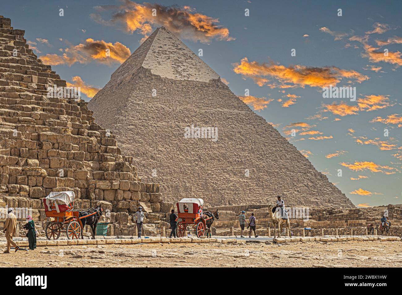 Gizeh Necropolis, Ägypten - 26. April 2022: Beduinen in traditionellen Kleidern und Touristen, vor dem Pyramidenkomplex von Gizeh Necropolis. Stockfoto