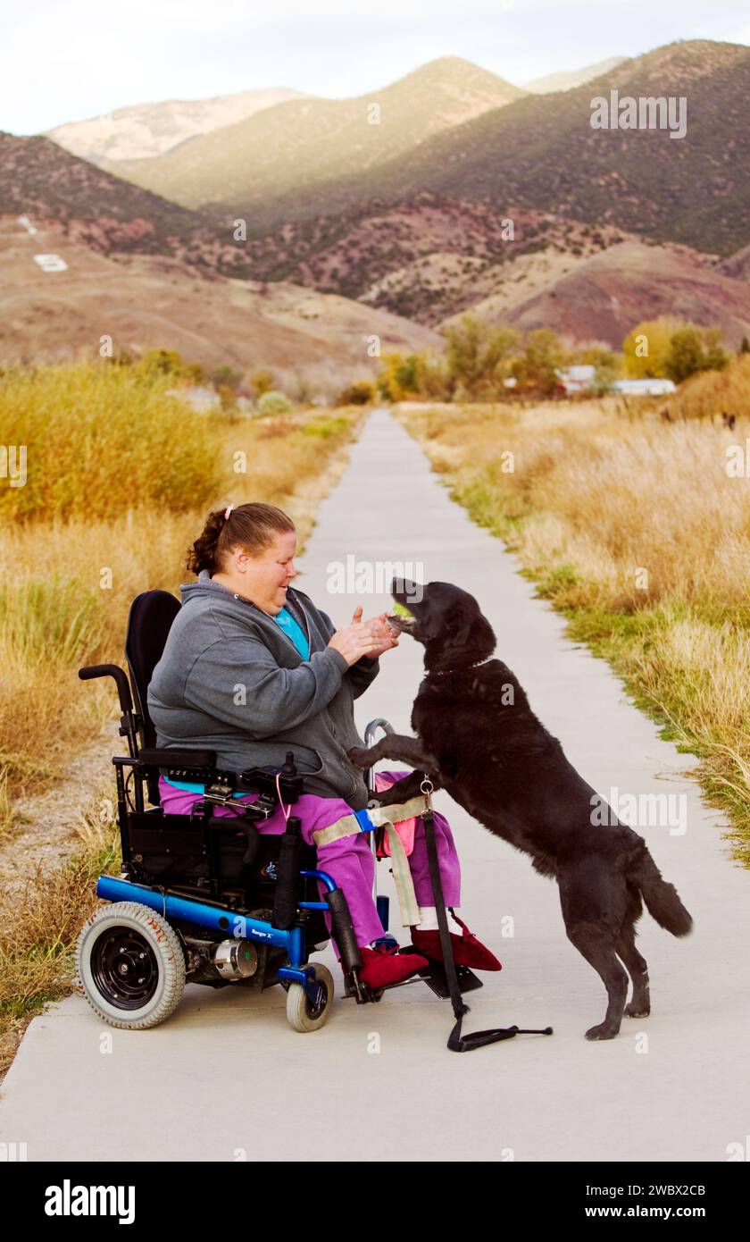 Frau benutzt ihren elektrischen Rollstuhl, um den Wanderweg in der kleinen Bergstadt Salida, Colorado, USA, zu befahren Stockfoto