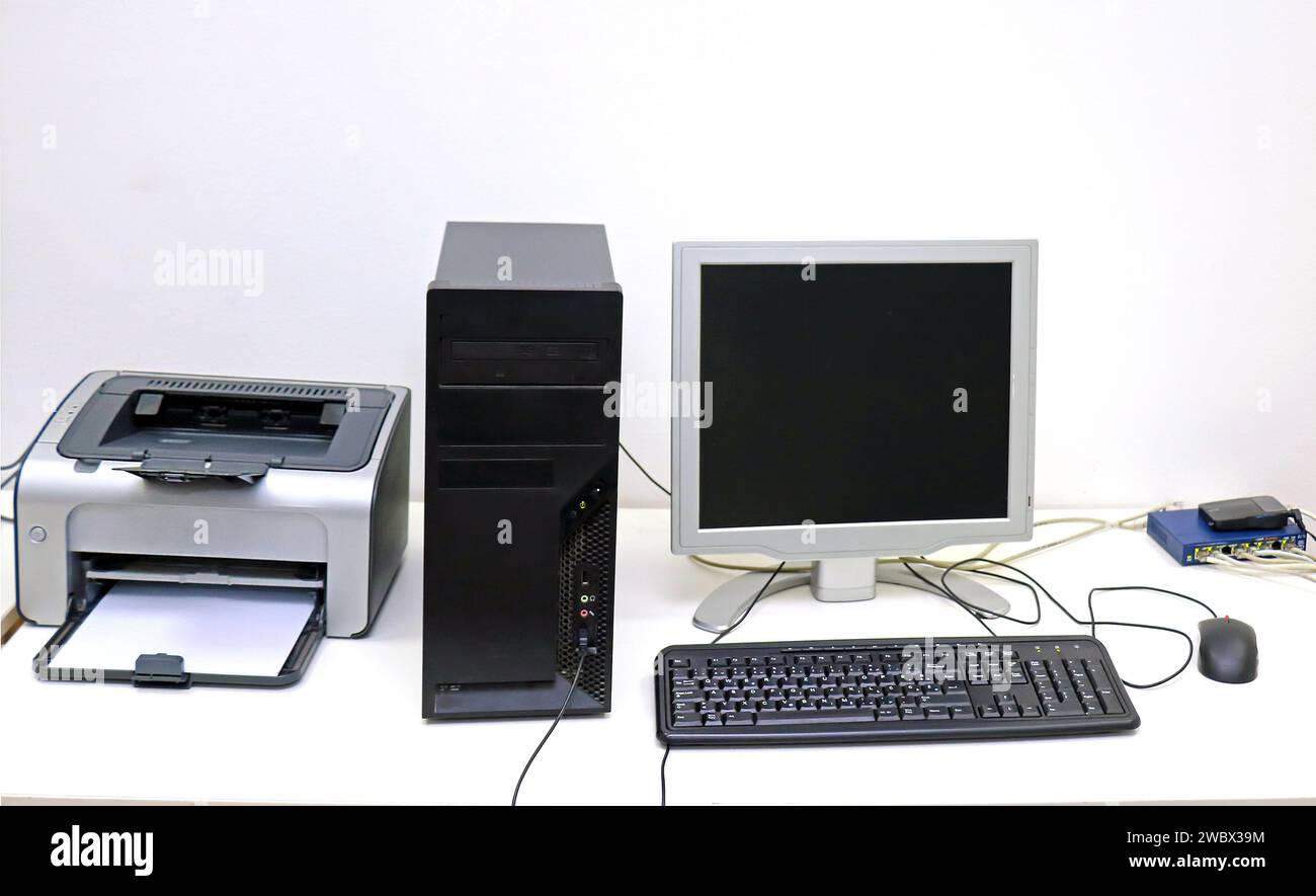 Desktop-Computer-Bildschirm und Tastatur mit Drucker im Innenraum des Büros Stockfoto