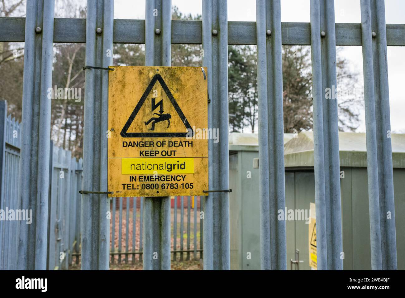 Gefahr, Elektrizität, Stromschlaggefahr, Warnhinweis an einem verzinkten Metallzaun angebracht. Stockfoto