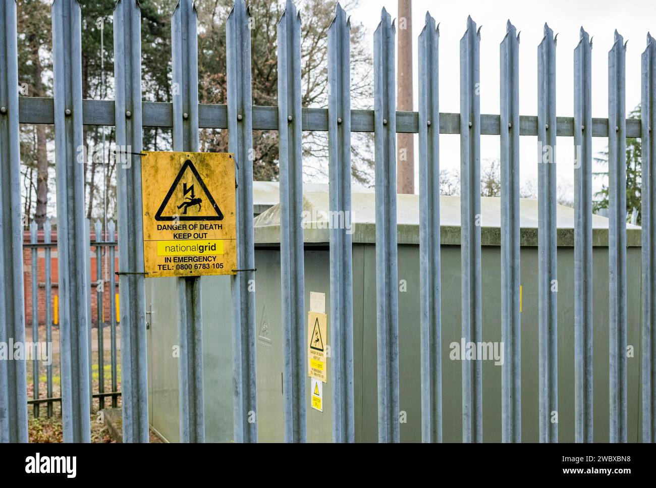 Gefahr, Elektrizität, Stromschlaggefahr, Warnhinweis an einem verzinkten Metallzaun angebracht. Stockfoto
