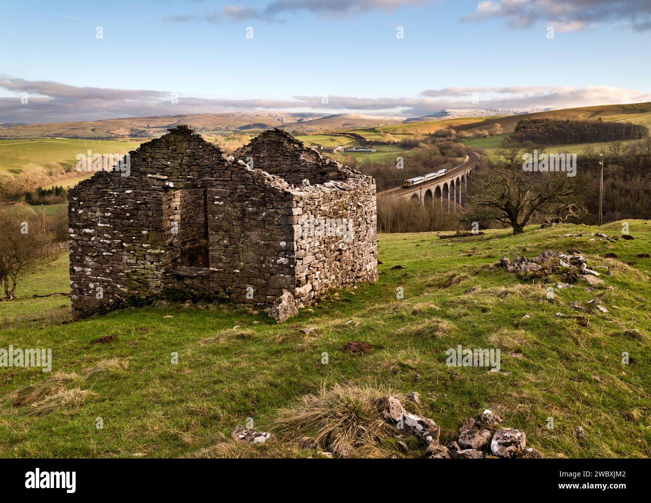 Ein Blick auf das Smardale Viaduct auf der Siedler-Carlisle-Eisenbahn in der Nähe von Crosby Garrett, Cumbria, mit einer Ruine landwirtschaftlicher Scheune im Vordergrund. Stockfoto