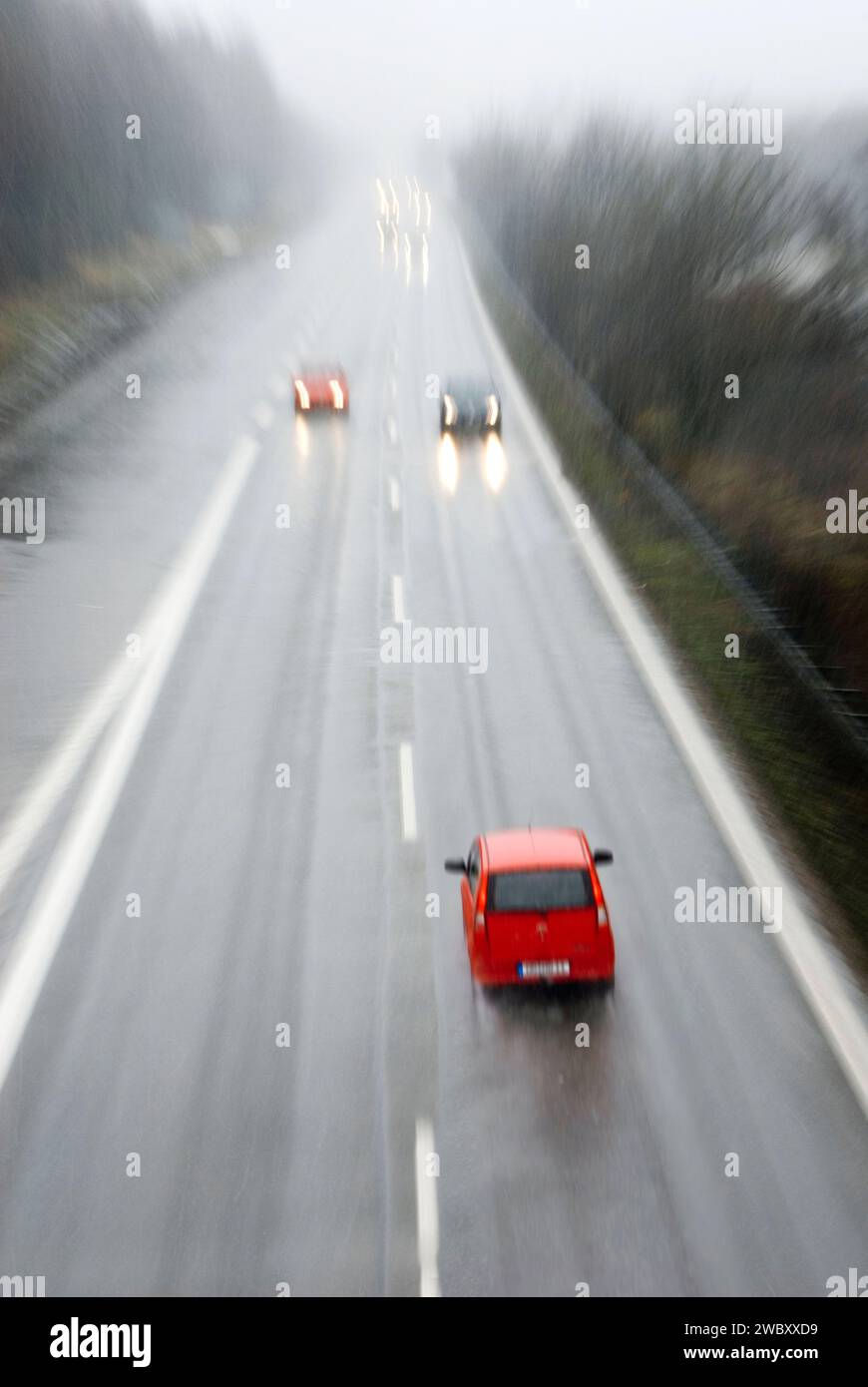 Geisterfahrer in rotem Kleinwagen in falscher Richtung auf der Autobahn, Autobahn bei München, Bayern, Deutschland, digitales Compositing Stockfoto