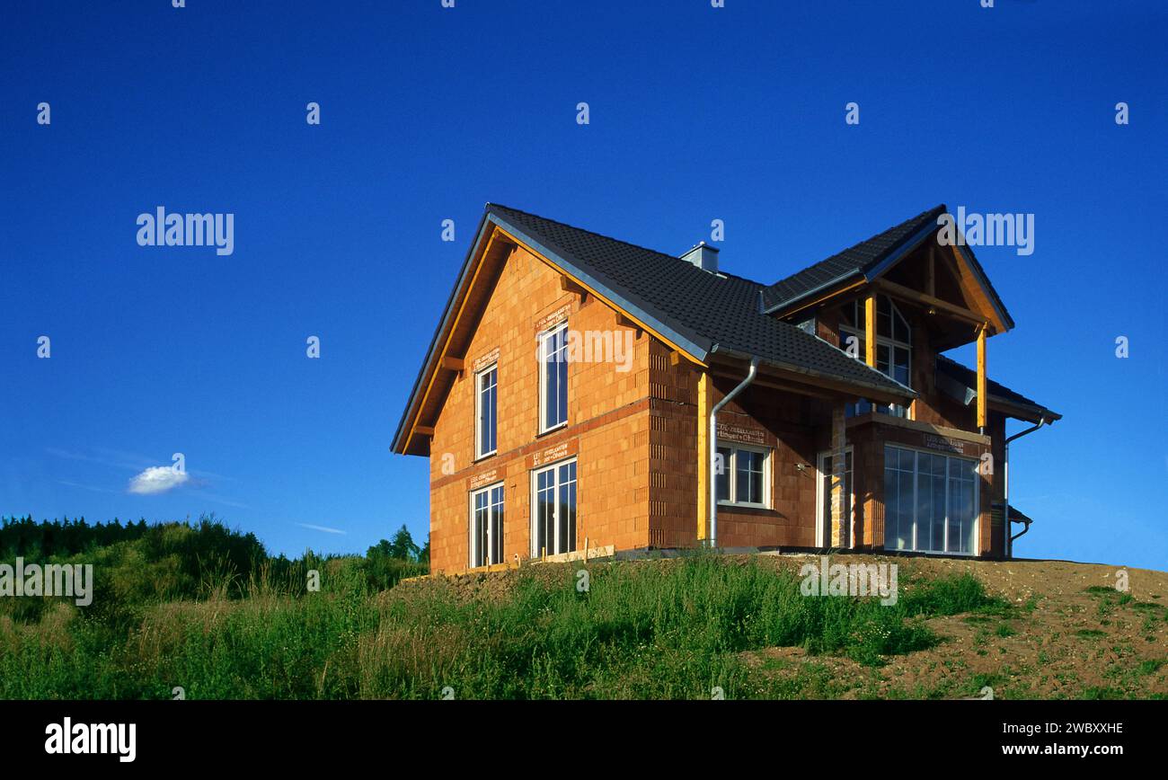Grober Bau eines deutschen Einfamilienhauses, Bild aus dem Jahr 2003, mit blauem Himmel in warmer Sonne, bei München, Bayern, Deutschland Stockfoto