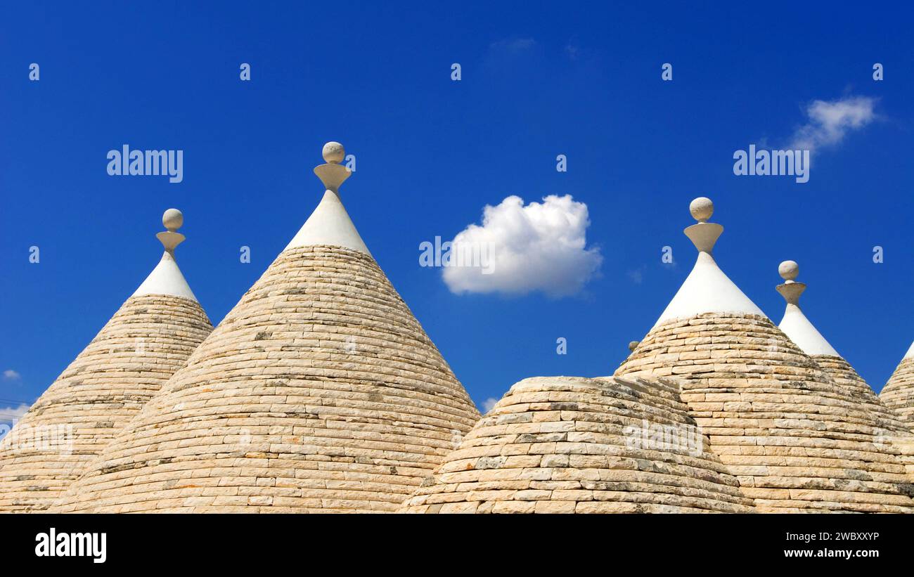Nahaufnahme des konischen Daches oder des Kegeldachs des Trullo House gegen blauen Himmel und weiße flauschige Wolke, in der Nähe der Stadt Alberobello, Apulien, Italien, Europa, Trull Stockfoto