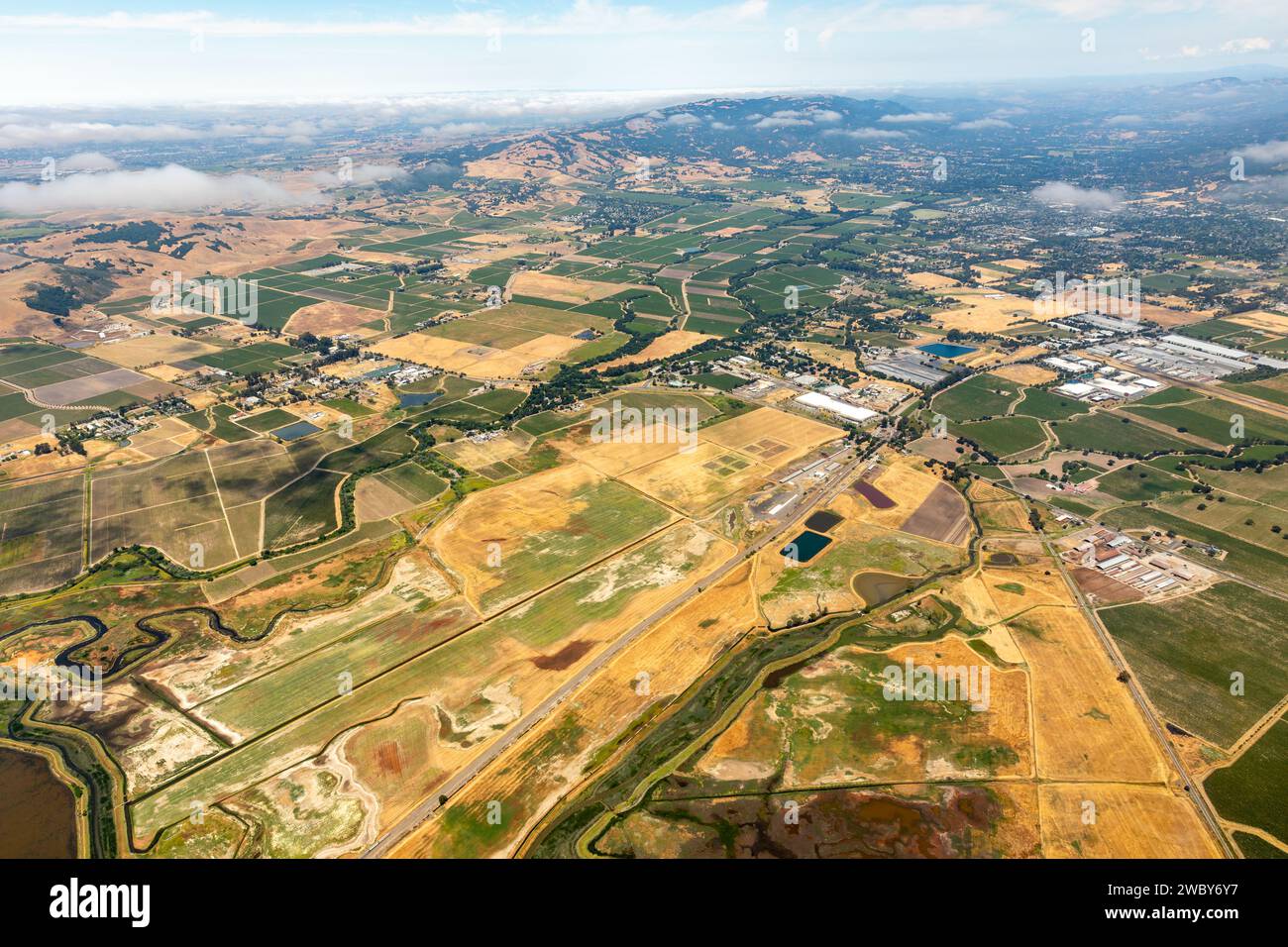 Aus der Vogelperspektive sehen Sie bunte Muster von landwirtschaftlichen Feldern und die Feuchtgebiete des Sacramento River Delta, während es die Northern San Francisco Bay erreicht Stockfoto