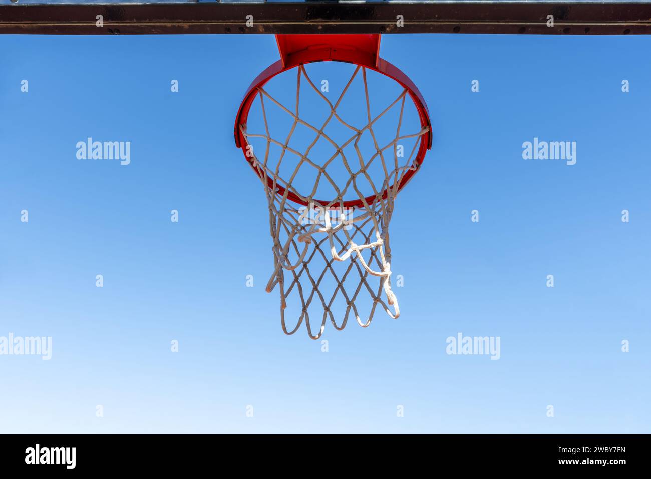 Ein Basketballkorb aus Metall in der typischen orangen Farbe vor blauem Himmel Stockfoto