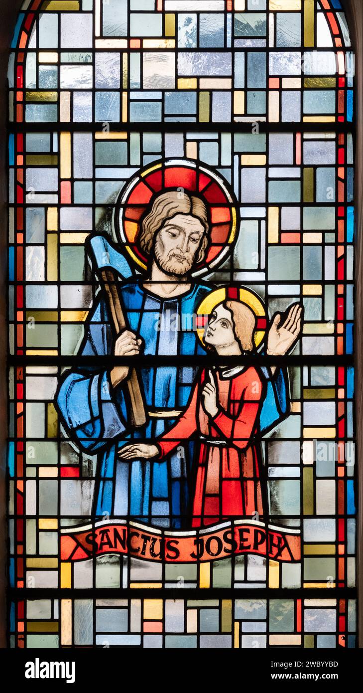 Der heilige Josef mit dem kleinen Jesus. Ein Buntglasfenster in der Eglise de la Sainte-Trinité (Heilige Dreifaltigkeitskirche) in Walferdange, Luxemburg. Stockfoto