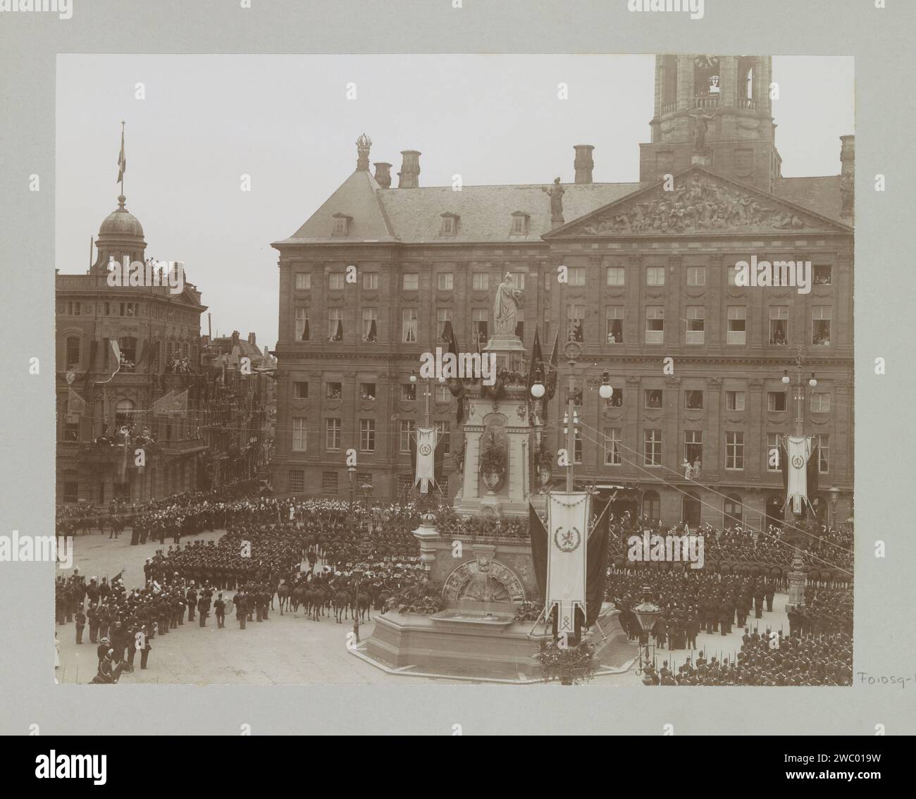 Militärgrüße an die eingeweihte Königin Wilhelmina und Königin Mutter Emma, beide stehen auf dem Balkon des Königspalastes am Dam Platz, Barend Groote (möglich), 1898 Foto Teil des Fotoalbums mit 15 Aufnahmen der Einweihung von Königin Wilhelmina und der Einweihungsparteien. Dam-fotografische Stützinstallation eines Lineals - BB - weibliches Lineal. Zeremonielle Feier der Einsetzung eines Herrschers. Öffentliche Feierlichkeiten anlässlich königlicher Veranstaltungen. (Militär-)Uniformen. palast. Herrscher, souverän. Denkmal, Statue Königspalast Amsterdam. Dam. Naatje auf dem Damplatz Stockfoto