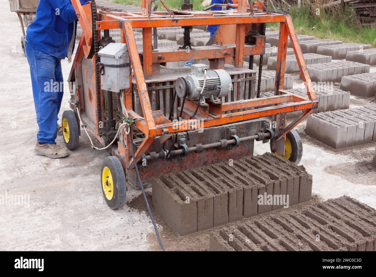 afrikanische man Ziegelbaumaschine, hergestellt aus Zementbeton und Sand Stockfoto