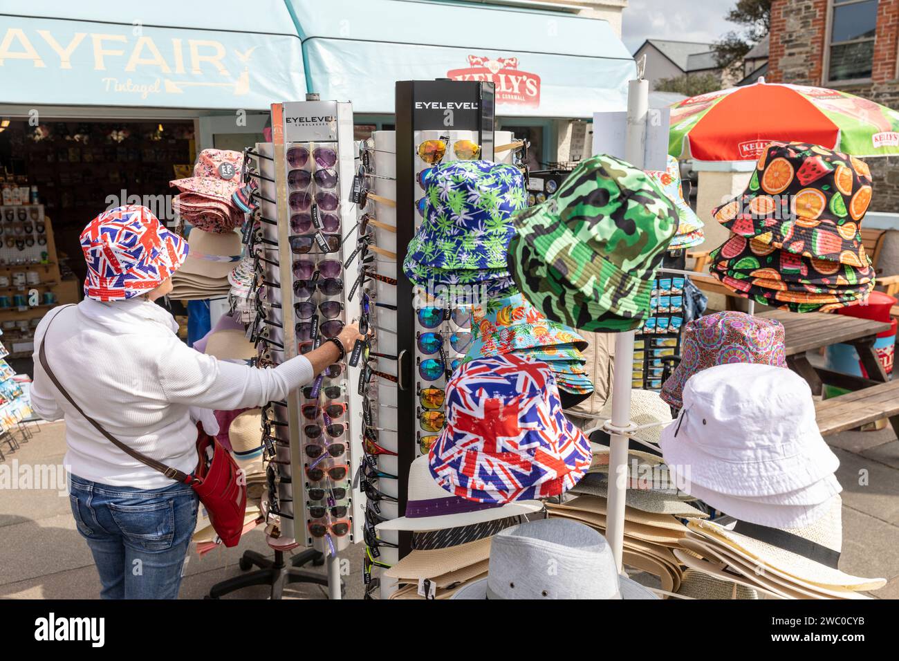 Union Jack Bucket Hits, Model veröffentlicht Frau versucht Union Jack Hut im Souvenirladen in Tintagel, Cornwall, England, UK, 2023 Stockfoto