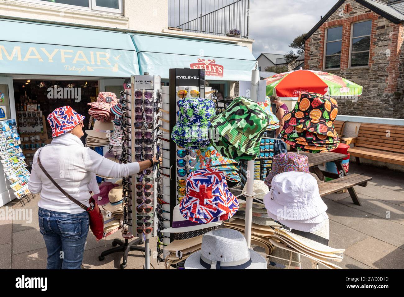 Union Jack Bucket Hits, Model veröffentlicht Frau versucht Union Jack Hut im Souvenirladen in Tintagel, Cornwall, England, UK, 2023 Stockfoto