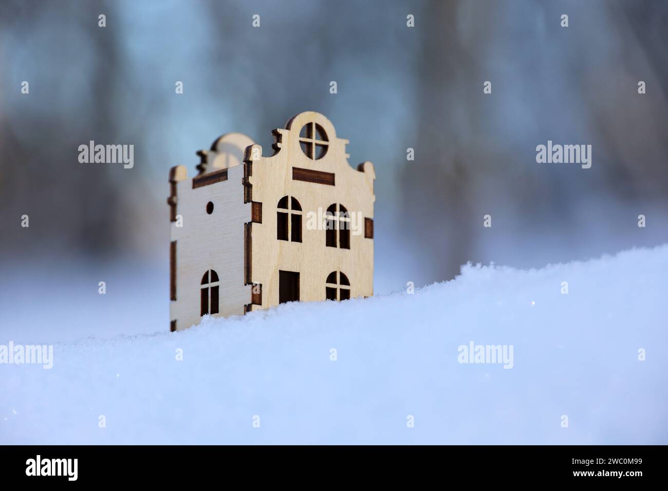 Hölzernes Hausmodell im Schnee auf Winterwald Hintergrund. Das Konzept der Immobilie im ökologisch sauberen Raum Stockfoto