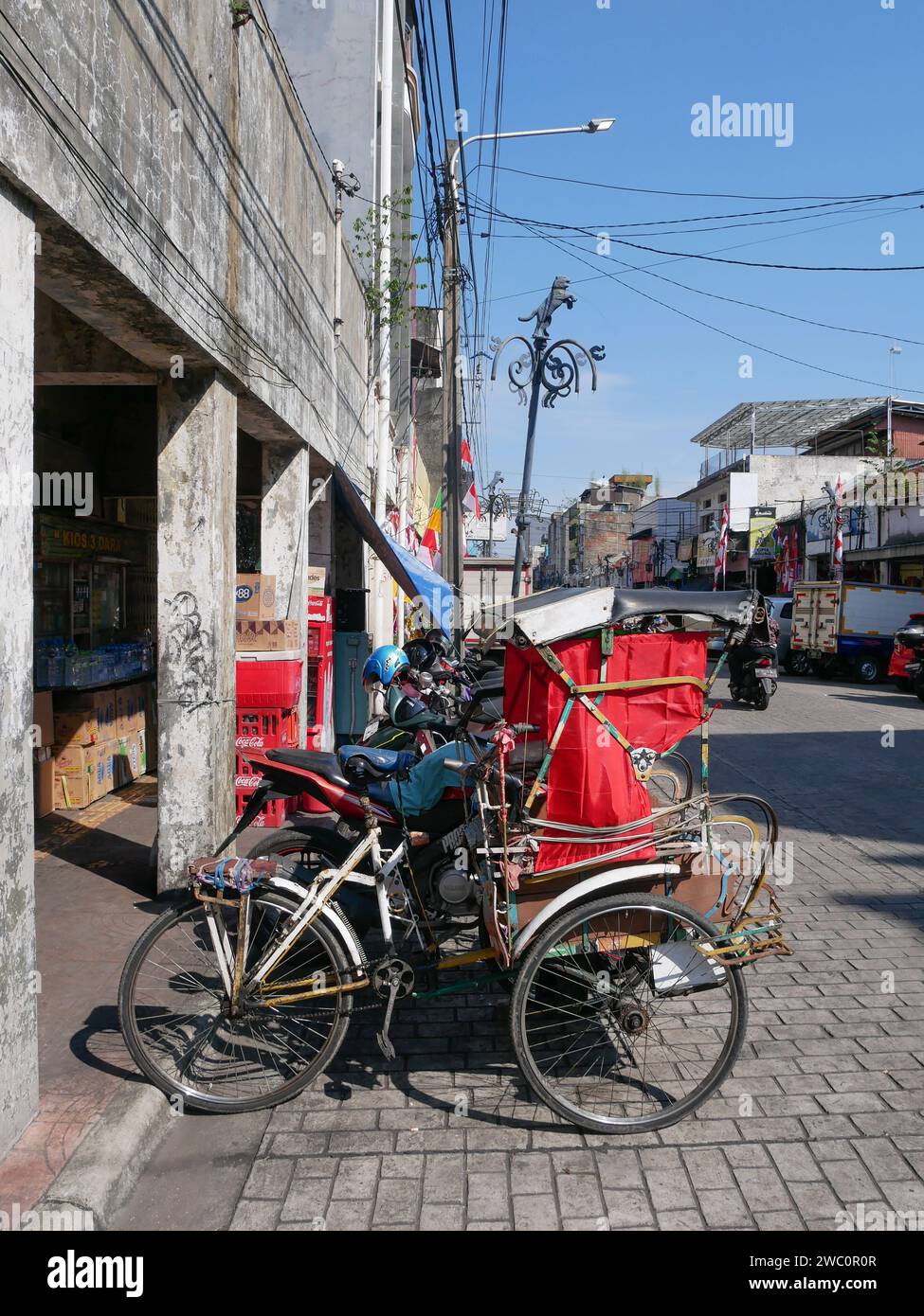 Pedicab oder Becak am Straßenrand in Bandung, West-Java, Indonesien. Stockfoto