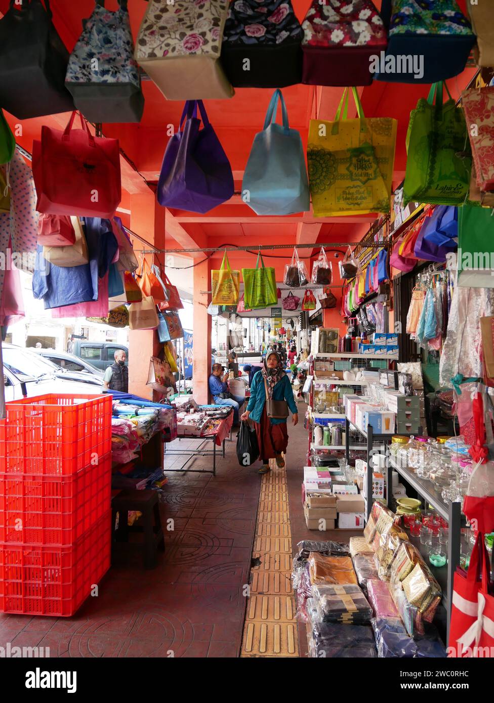 Geschäfte mit Häusern in der alten Bandung City auf Jl. Cibadak in West-Java, Indonesien mit überdachtem gepflasterten Bereich, wo viele Waren wie Taschen zum Verkauf angeboten werden. Stockfoto